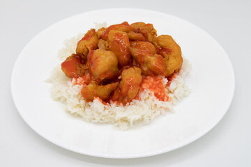 Sweet and Sour Chicken on White Rice on top of a White Plate