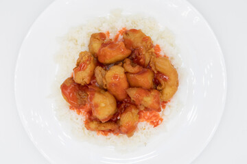 Sweet and Sour Chicken on White Rice on top of a White Plate