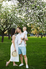 Fototapeta premium The young handsome family is spending time at nature on a summer day.