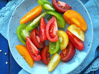 Fresh salad made from colored tomatoes - yellow, red, green and orange