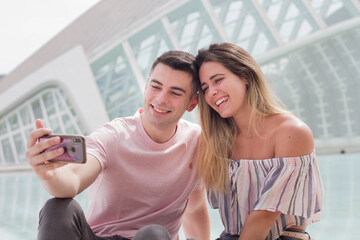 Enjoying Media Content Concept. Lovely couple using phone, choosing something, making online order,...
