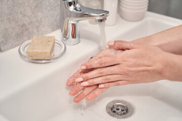 Young Caucasian lady performing a handwashing procedure