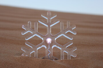 Transparent snowflake in desert sand dune. Merry Christmas/Christmas/Happy Holidays/Season's...
