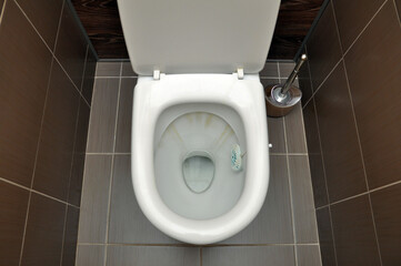 Fototapeta premium A white toilet with traces of rust from the flushing water. Hygiene