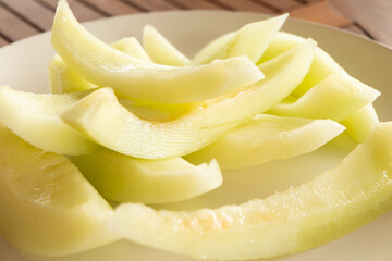 Sliced yellow melon on a white plate