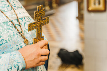 Holy father in his robe with a golden cross in his hands in church. Orthodox tradition and faith. Equipment for praying. Pray for people life. Pray to god