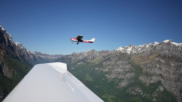 Close up formation flight over Switzerland. Window view from inside a small private plane. Beautiful, scenic, panoramic view of Swiss mountains. Aerial shot.
