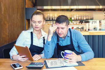 Mature new small business owners calculating online restaurant bill expenses and taxes - 357874964