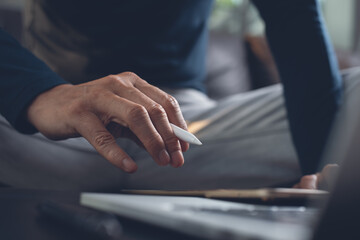 Casual man graphic designer working on digital tablet at home office