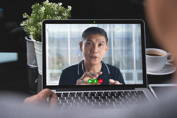 Man using zoom online meeting app for video conference via laptop computer while working from home