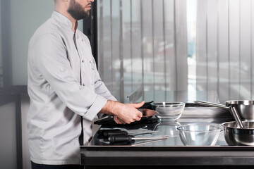 Male chef hands with knives. Closeup professional testing kitchen staff.