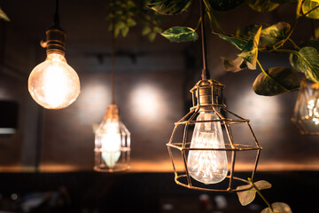 An antique design lighting bulb/chandelier with metal rusty cage that hanging for room interior decoration. Selective focus on one lighting lamp.