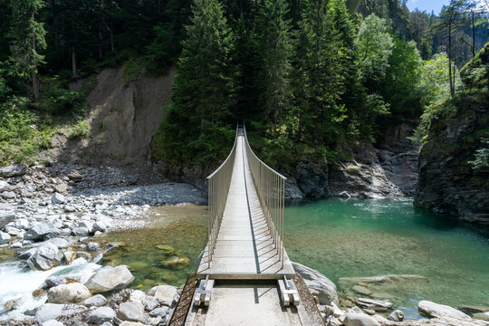 wooden suspension bridge across the Rhine River in the heart of the Viamala Gorge in the Swiss Alps