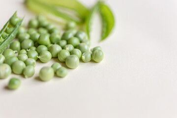 Fresh peas isolated on yelow background.Top view, selected focus. Heart shape.