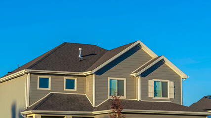 Panorama frame Home exterior with view of the upper storey agaist clear blue sky background