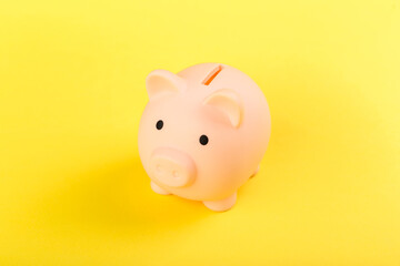 pink piggy bank on a yellow background. Concept of saving money or savings, investment.