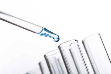pipette with a drop and scientific laboratory test tubes in a research laboratory.