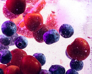 Close up view of the cold and fresh lemonade with bright berries and ice cubes in neon light....