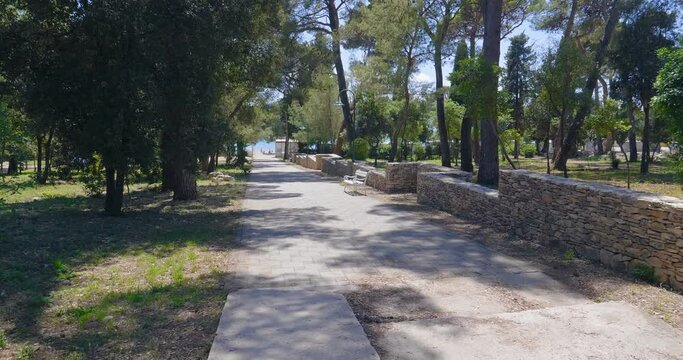 Promenade towards the beach in Biograd na Moru, Croatia. Empty benches. Sunny summer day.

