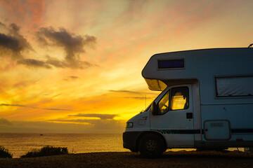 Fototapeta premium Camper vehicle on beach at sunrise