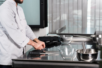 Male chef hands at kitchen restaurant. Professional male with kitchen staff.