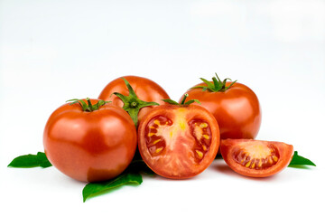 Fresh tomatoes with green leaves isolated on a white background.