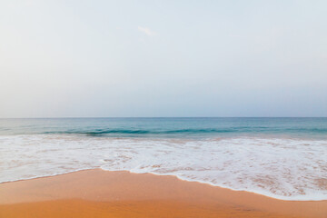 Foamy waves on sandy ocean beach coast of Sri Lanka island.