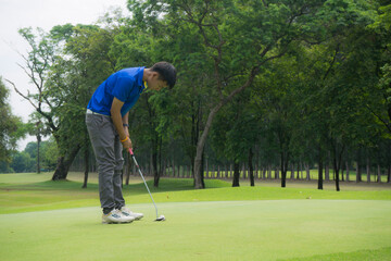 Blurred golfers are playing golf in the evening golf course in thailand. Golf ball and golf club in beautiful golf course at sunset background