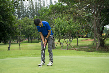 Blurred golfers are playing golf in the evening golf course in thailand. Golf ball and golf club in beautiful golf course at sunset background