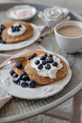 Healthy breakfast concept. Oatmeal pancakes topped with yogurt and blueberries