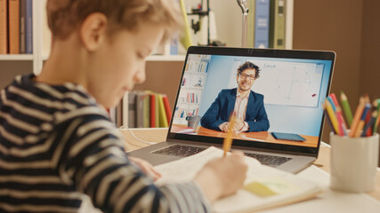 Smart Little Boy Uses Laptop for Video Call with His Teacher. Screen Shows Online Lecture with...