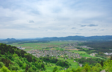 Fototapeta na wymiar Slovenian countryside in spring with charming little village and Julian Alps in the background