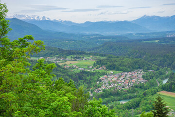 Fototapeta na wymiar Slovenian countryside in spring with charming little village and Julian Alps in the background