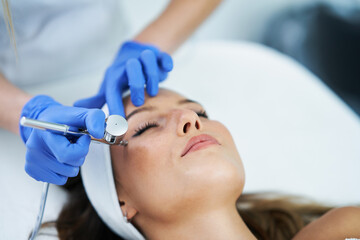 Obraz na płótnie Canvas Beautiful young woman getting face treatment at beauty salon.