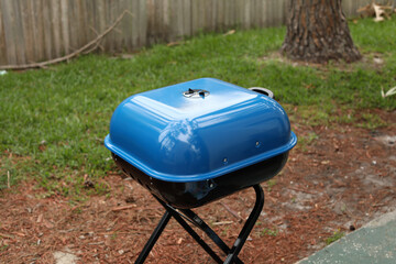 small blue grill in the back yard