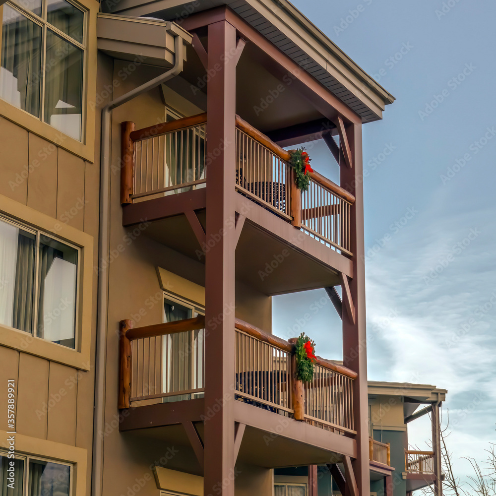 Wall mural Square crop Residential building balconies with festive Christmas wreath against blue sky