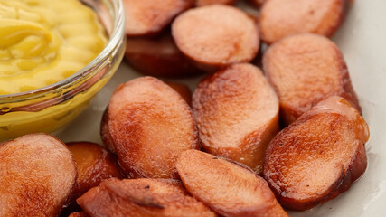 fried sausages with mustard. closeup top view