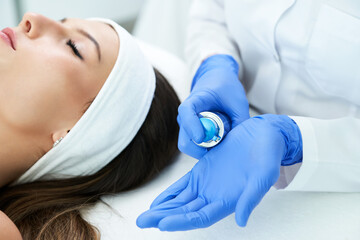 Beautiful young woman getting face treatment at beauty salon.