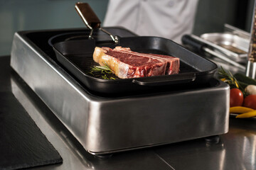 Fresh steak lay at griddle pan. Closeup raw beef lay at pan.