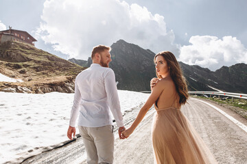Beautiful young couple in stunning mountains landscape. Photo from the drone. Wedding walk in the mountains