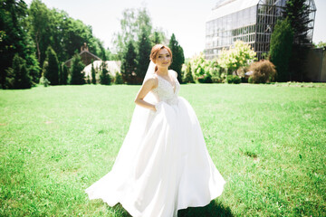 Beautiful bride posing in wedding dress outdoors