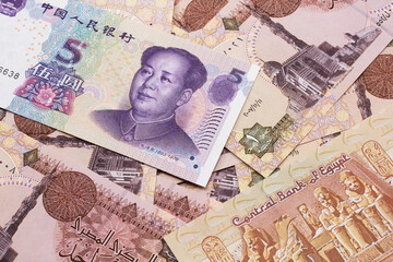 A close up image of a purple, five Chinese yuan bank note, close up on a background of blue Egyptian one pound bank notes.  Shot in macro
