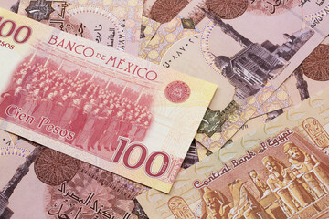 A close up image of a Mexican one hundred peso bank note with Egyptian one pound bank notes in macro