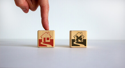 Hand making a choice between two cubes with house icon on beautiful white background. Business and crisis recovery concept.