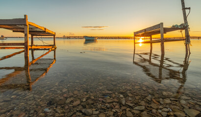 Coucher de soleil sur un étang avec des parcs à élevage de moules.