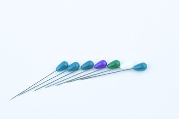 Six different colored brooches pin placed beside each other on a white background