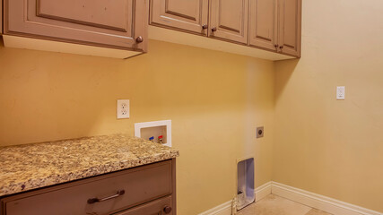 Panorama Interior of home kitchen with wood cabinets and gas line for cooking appliances