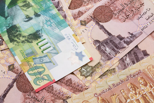 A close up image of a twenty shekel bank note from Israel on a background of Egyptian one pound bank notes in macro