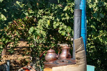 Traditional copper teapot on a old stove in garden.