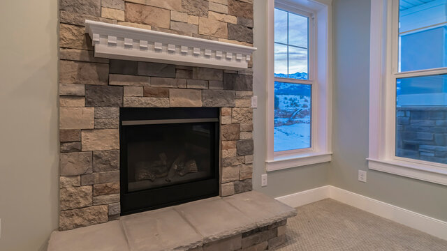 Panorama Crop Modern Fireplace And Decorative Shelf Against Stone Brick Accent Wall Of Home